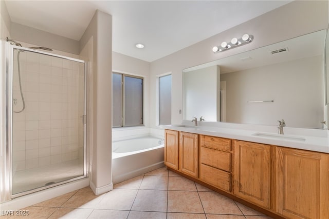 bathroom with tile patterned flooring, vanity, and shower with separate bathtub