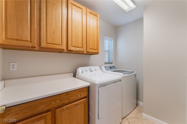 washroom featuring cabinets, light tile patterned flooring, and washer and dryer