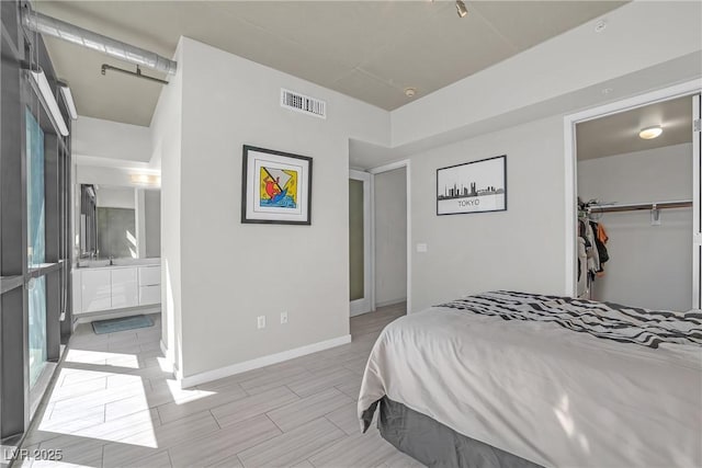 bedroom featuring a spacious closet, connected bathroom, and a closet