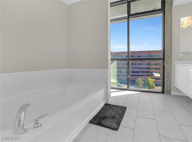 bathroom featuring expansive windows, vanity, and a bath