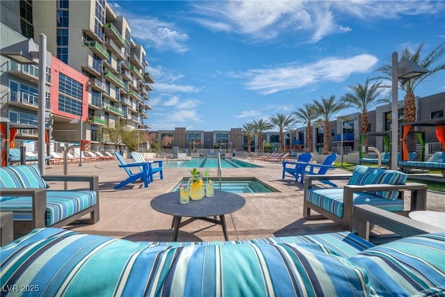 view of swimming pool featuring a patio area and a hot tub