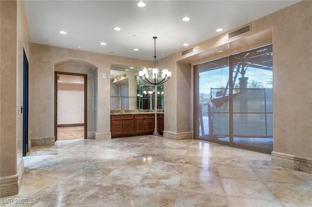 unfurnished dining area featuring a chandelier