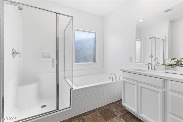 bathroom featuring vanity and independent shower and bath