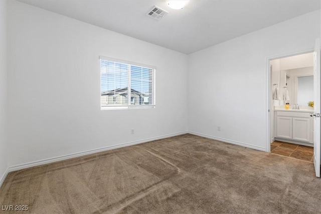 unfurnished bedroom featuring connected bathroom and carpet flooring