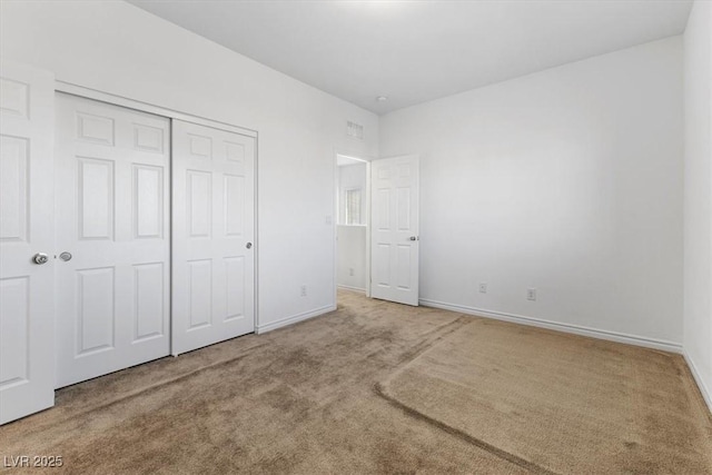 unfurnished bedroom featuring carpet floors and a closet