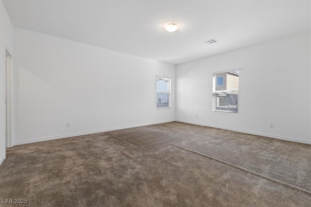 spare room with dark colored carpet