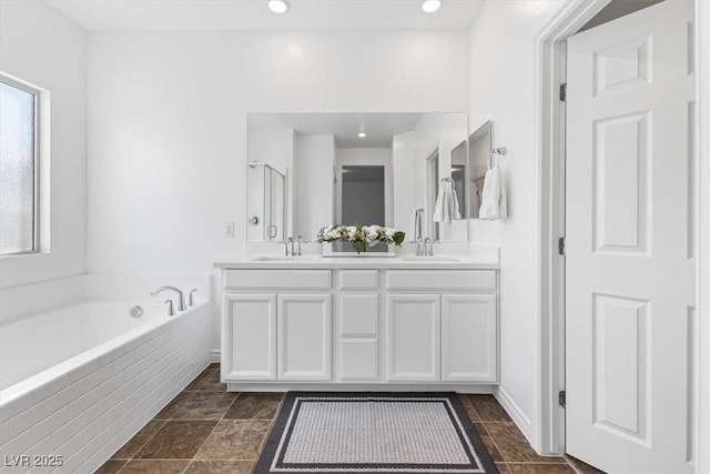 bathroom with vanity and separate shower and tub