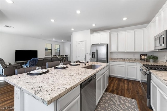 kitchen featuring sink, appliances with stainless steel finishes, dark hardwood / wood-style floors, an island with sink, and white cabinets