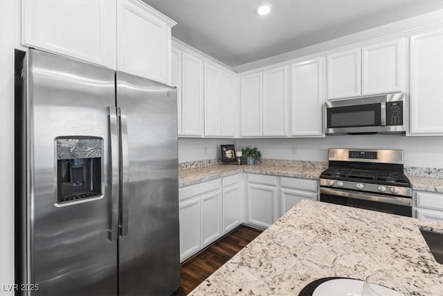 kitchen featuring white cabinetry, light stone countertops, and stainless steel appliances