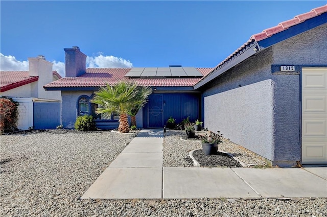 property entrance featuring a garage and solar panels