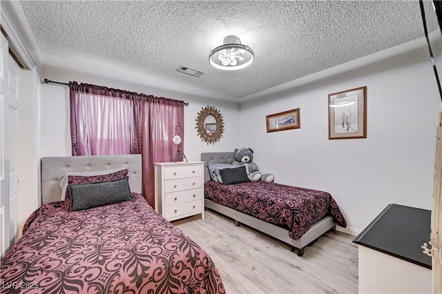 bedroom featuring a textured ceiling, a closet, and light wood-type flooring