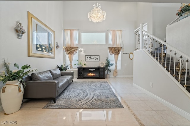 living room featuring light tile patterned flooring, a towering ceiling, and a chandelier