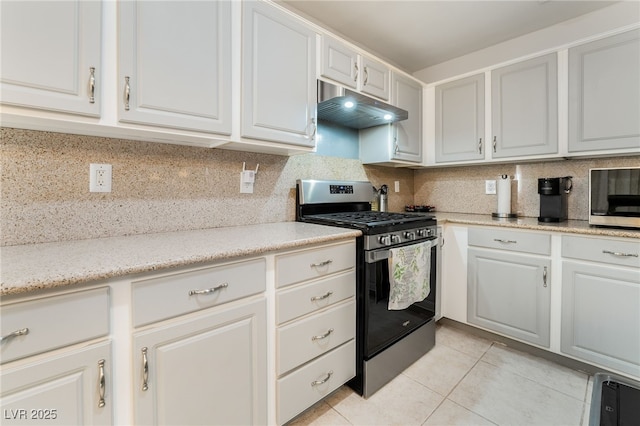 kitchen featuring stainless steel appliances, light tile patterned floors, white cabinets, and decorative backsplash