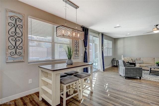 dining room with wood finished floors, visible vents, and baseboards