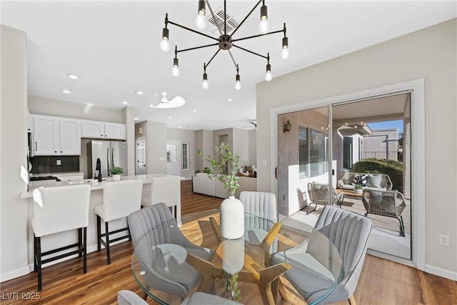 dining space with hardwood / wood-style flooring and an inviting chandelier