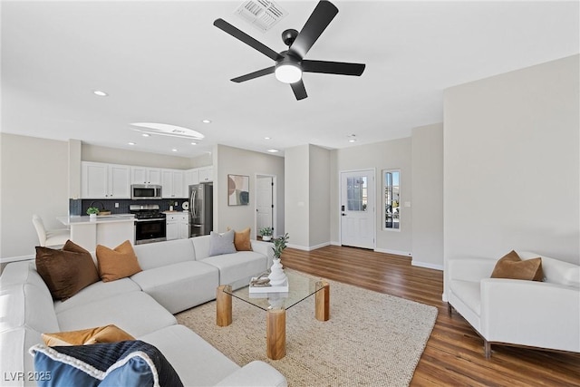 living room with ceiling fan and dark hardwood / wood-style flooring