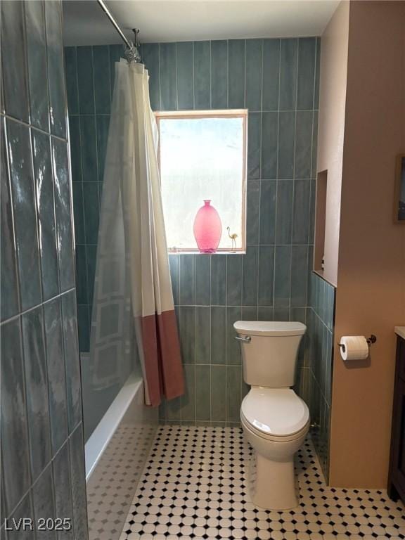 bathroom with toilet, shower / bathtub combination with curtain, tile patterned flooring, and tile walls