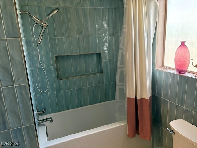 bathroom featuring tile walls, shower / bath combination with curtain, and toilet