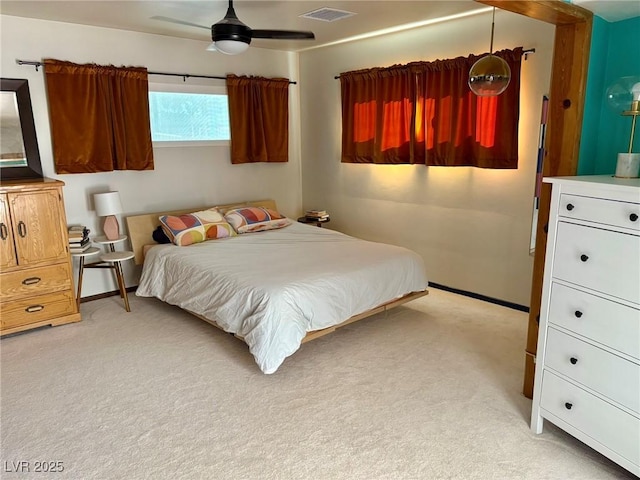 bedroom with baseboards, visible vents, and light colored carpet