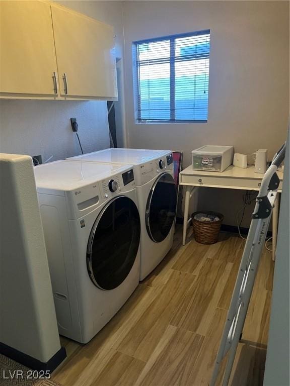 laundry room with light wood finished floors, cabinet space, and washer and dryer