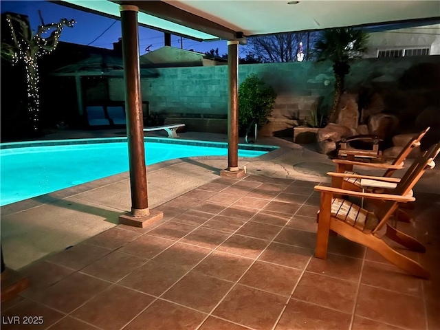 outdoor pool featuring a patio area, a fenced backyard, and a diving board