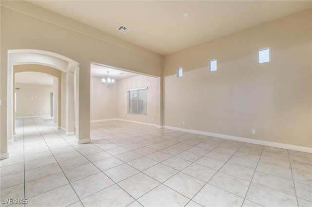 empty room featuring light tile patterned floors and a chandelier