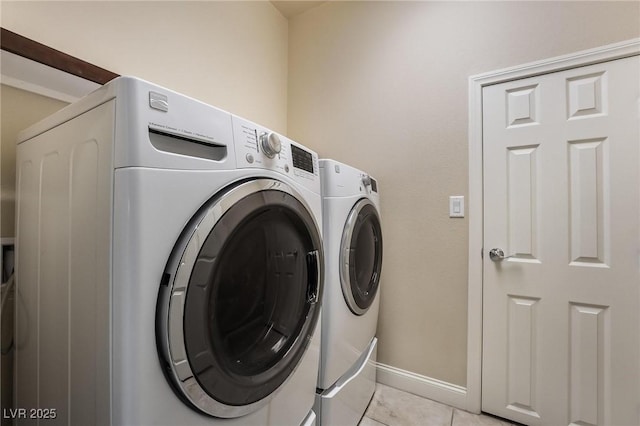 laundry room featuring separate washer and dryer and light tile patterned flooring