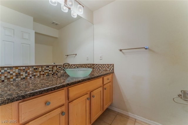 bathroom with vanity, tile patterned flooring, and backsplash