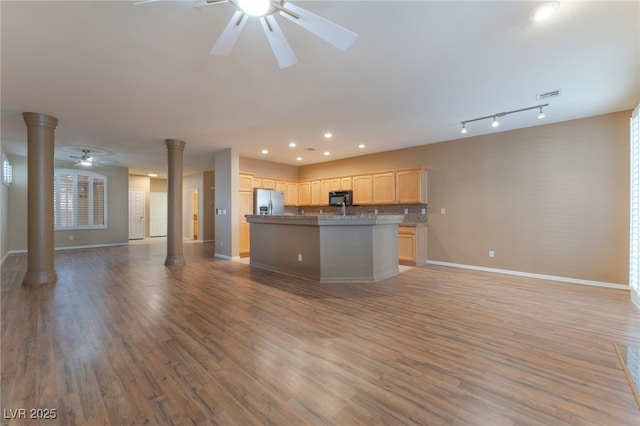 kitchen featuring ceiling fan, a kitchen island with sink, decorative columns, light hardwood / wood-style floors, and light brown cabinets