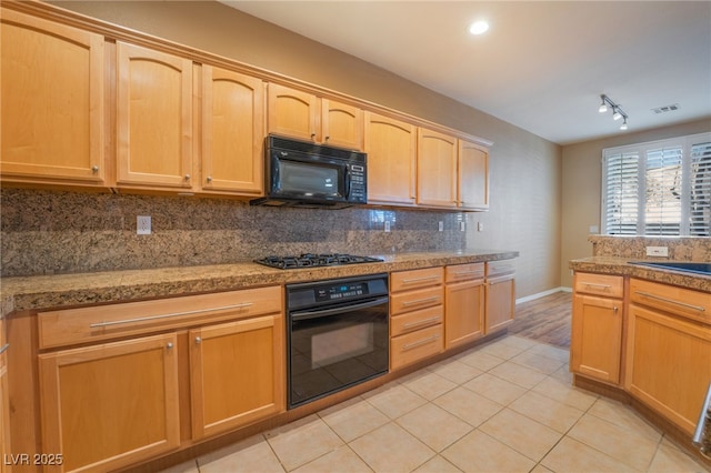 kitchen with backsplash, light tile patterned floors, black appliances, and light brown cabinets