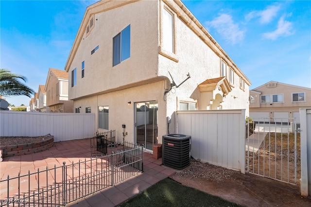 rear view of property with cooling unit and a patio