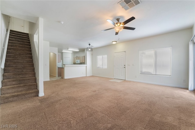 unfurnished living room featuring ceiling fan and carpet flooring