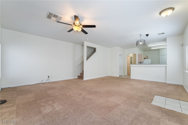 unfurnished living room featuring ceiling fan and light colored carpet