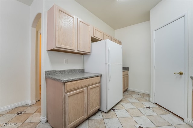 kitchen featuring light tile patterned flooring, light brown cabinets, and white refrigerator