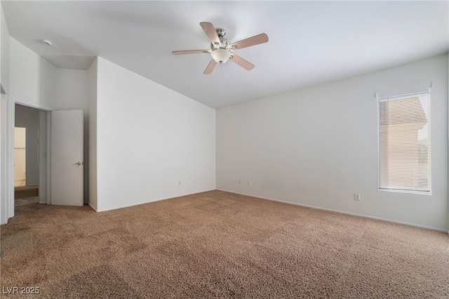 spare room featuring carpet floors, ceiling fan, and vaulted ceiling