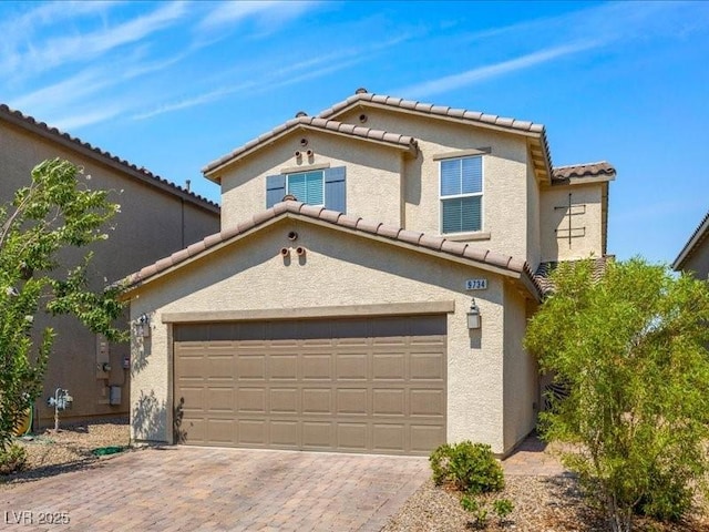 view of front of home with a garage, a tile roof, decorative driveway, and stucco siding