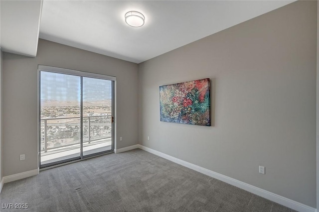 carpeted empty room with baseboards