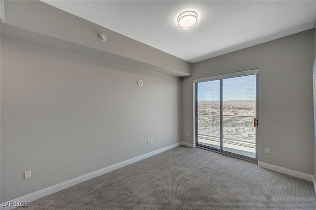 unfurnished room with baseboards and light colored carpet