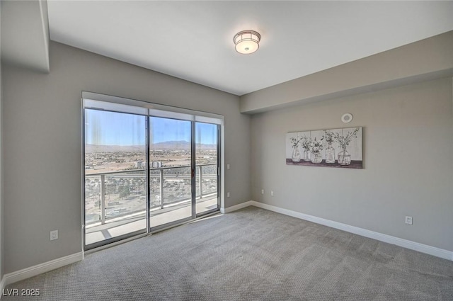 empty room featuring carpet floors and baseboards