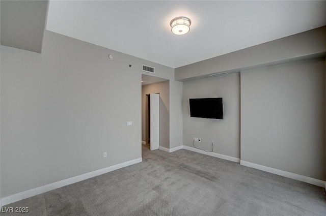 unfurnished room with baseboards, visible vents, and light colored carpet