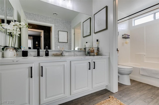 full bathroom with vanity, toilet, hardwood / wood-style floors, and shower / bathing tub combination