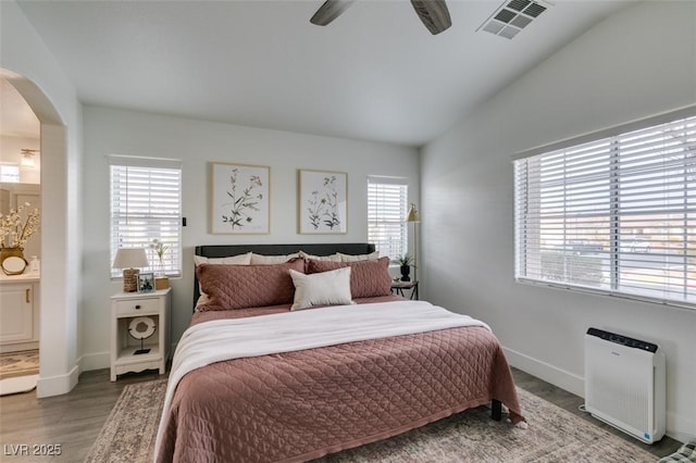 bedroom featuring multiple windows, lofted ceiling, and hardwood / wood-style floors