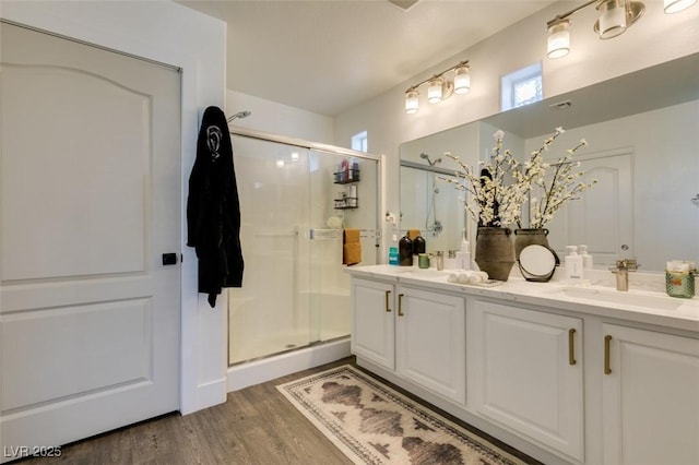 bathroom with wood-type flooring, an enclosed shower, and vanity