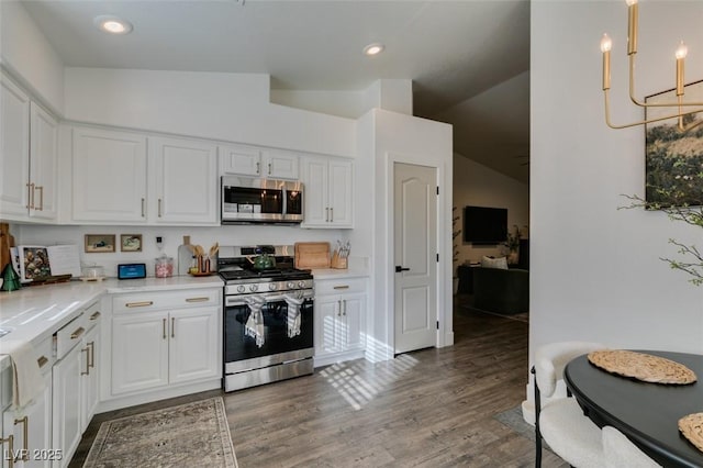 kitchen featuring stainless steel appliances, vaulted ceiling, dark hardwood / wood-style floors, and white cabinets