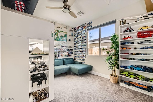 living area featuring carpet floors and ceiling fan