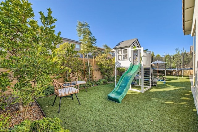 view of jungle gym with a yard and a trampoline