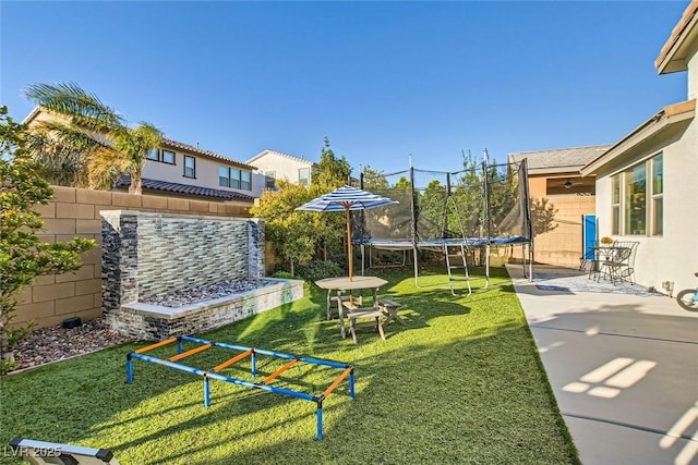 view of yard featuring a trampoline and a patio area