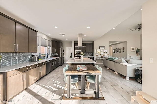 kitchen featuring sink, dishwasher, backsplash, a center island, and island exhaust hood