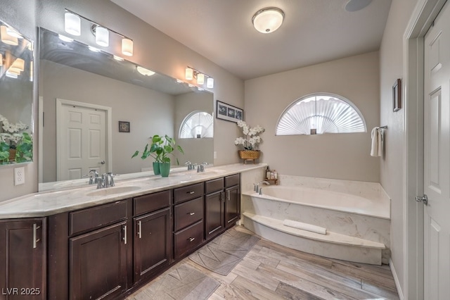 6461 Mount Eden Ave, Las Vegas, NV 89139 - full bath with double vanity, wood finished floors, a garden tub, and a sink