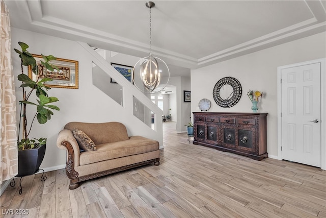 6461 Mount Eden Ave, Las Vegas, NV 89139 - living area with light wood finished floors, a tray ceiling, a notable chandelier, stairway, and baseboards